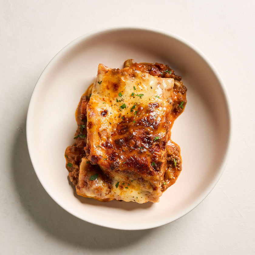 Organic beef lasagna on white plate - organic ready meal delivered in SA