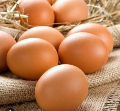 Fresh brown organic eggs grouped on rustic burlap fabric with hay in background - certified organic eggs SA home delivery